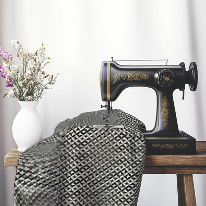 Pale Cream Cotton Sateen Fabric with Black Single Weave Motif Print, FASC-1013-142, on an antique sewing machine sitting on a desk with vase of beautiful flowers.