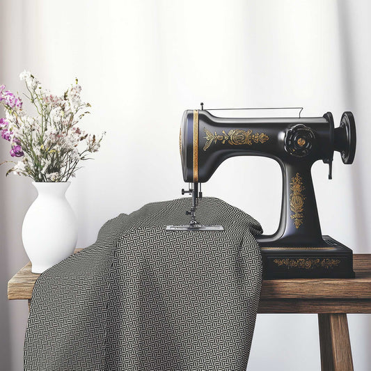Pale Cream Cotton Sateen Fabric with Black Double Weave Motif Print, FASC-1013-144, on an antique sewing machine sitting on a desk with vase of beautiful flowers.
