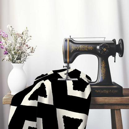Black Cotton Sateen with Bold Pale Cream Graphic , FASC-1013-392, on an antique sewing machine sitting on a desk with vase of beautiful flowers.