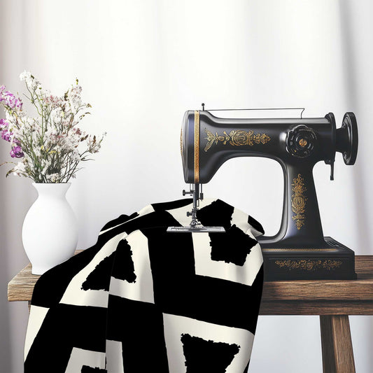 Black Cotton Sateen with Bold Pale Cream Graphic , FASC-1013-392, on an antique sewing machine sitting on a desk with vase of beautiful flowers.