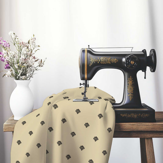 Tan Cotton Sateen Fabric with Black Hand-painted Swizzle Motif Print, FASC-1014-171, on an antique sewing machine sitting on a desk with vase of beautiful flowers.