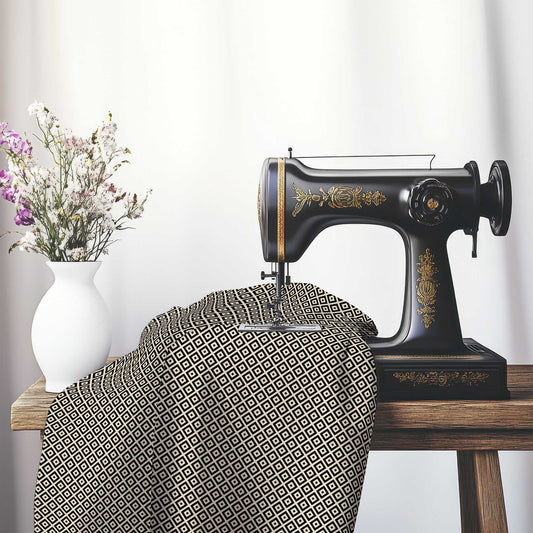 Beige Cotton Sateen Fabric with Black Repeating Square Motif Print, FASC-1015-122, on an antique sewing machine sitting on a desk with vase of beautiful flowers.
