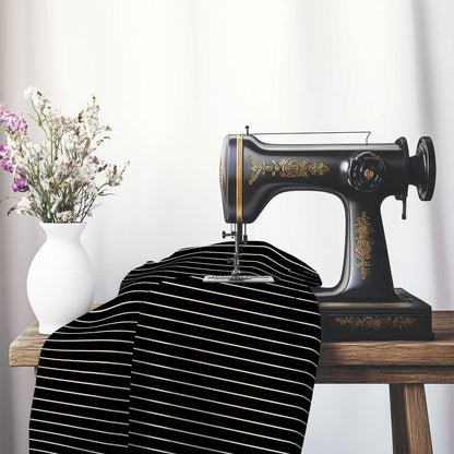 Cotton Sateen Fabric with Fine Beige Stripes on Black, FACS-1015-152, on an antique sewing machine sitting on a desk with vase of beautiful flowers.