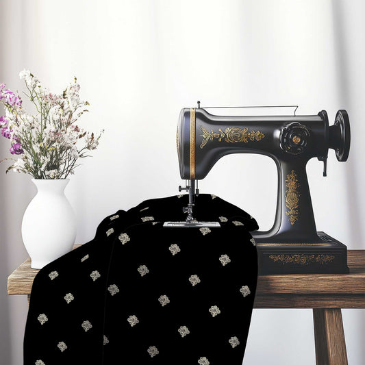 Black Cotton Sateen Fabric with Beige Hand-painted Swizzle Motif Print, FASC-1015-172, on an antique sewing machine sitting on a desk with vase of beautiful flowers.