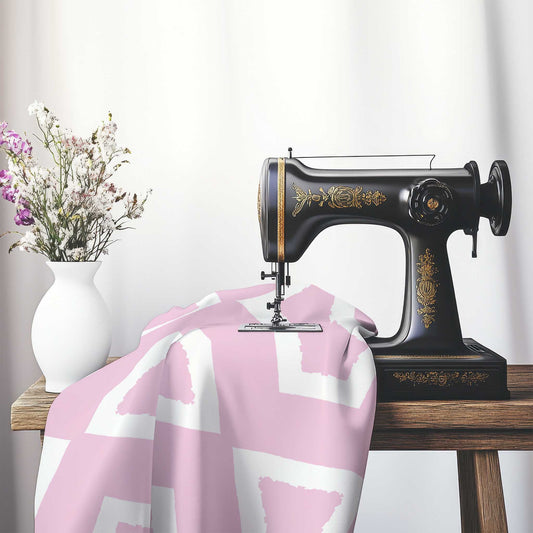 Pink Cotton Sateen Fabric with Bold Off-White Graphic , FASC-1081-392, on an antique sewing machine sitting on a desk with vase of beautiful flowers.