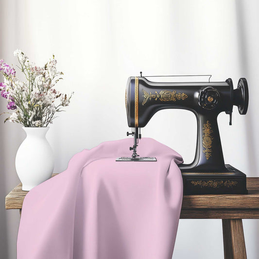 Pink Cotton Sateen Fabric, FACS-1081-999, on an antique sewing machine sitting on a desk with vase of beautiful flowers.