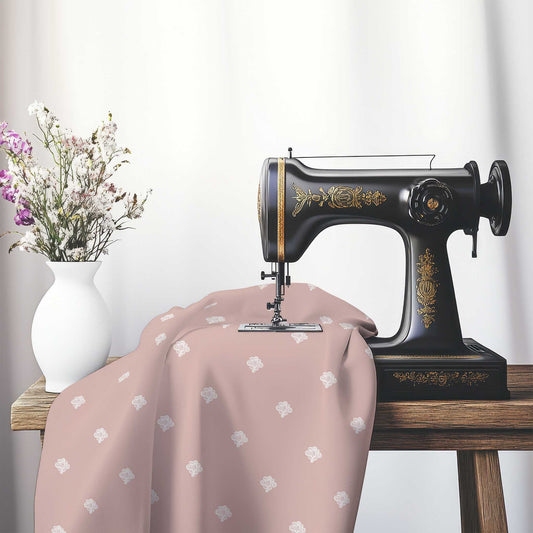 Salmon Cotton Sateen Fabric with Off-White Hand-painted Swizzle Motif Print, FASC-1139-172, on an antique sewing machine sitting on a desk with vase of beautiful flowers.