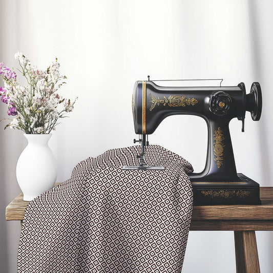 Off-White Cotton Sateen Fabric with Brown Repeating Square Motif Print, FASC-1161-122, on an antique sewing machine sitting on a desk with vase of beautiful flowers.