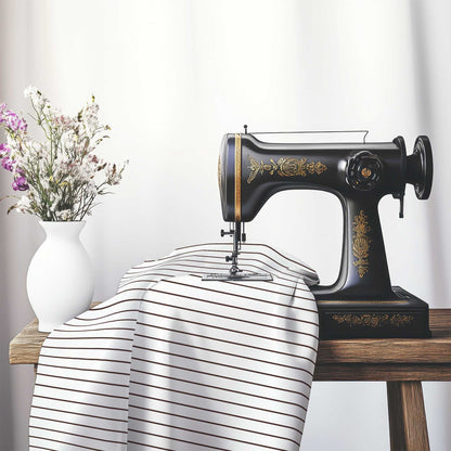 White Cotton Sateen Fabric with Fine Brown Stripes, FACS-1161-151, on an antique sewing machine sitting on a desk with vase of beautiful flowers.