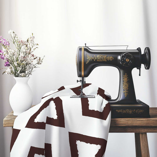 Off-White Cotton Sateen Fabric with Bold Brown Graphic , FASC-1161-391, on an antique sewing machine sitting on a desk with vase of beautiful flowers.