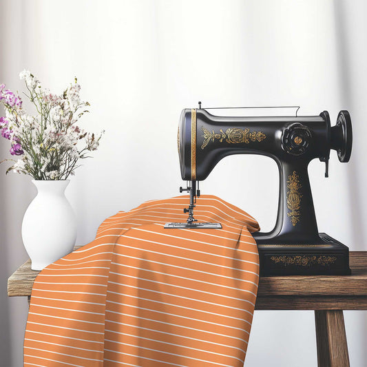Cotton Sateen Fabric with Fine White Stripes on Orange, FACS-1181-152, on an antique sewing machine sitting on a desk with vase of beautiful flowers.