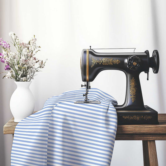 White Cotton Sateen Fabric with Thin Blue Bars, FACS-1231-241, on an antique sewing machine sitting on a desk with vase of beautiful flowers.