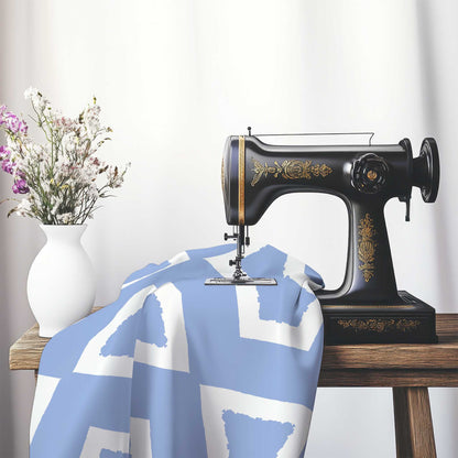 Blue Cotton Sateen Fabric with Bold Off-White Graphic , FASC-1231-392, on an antique sewing machine sitting on a desk with vase of beautiful flowers.