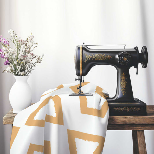 Off-White Cotton Sateen Fabric with Bold Pale Orange Graphic , FASC-1232-391, on an antique sewing machine sitting on a desk with vase of beautiful flowers.