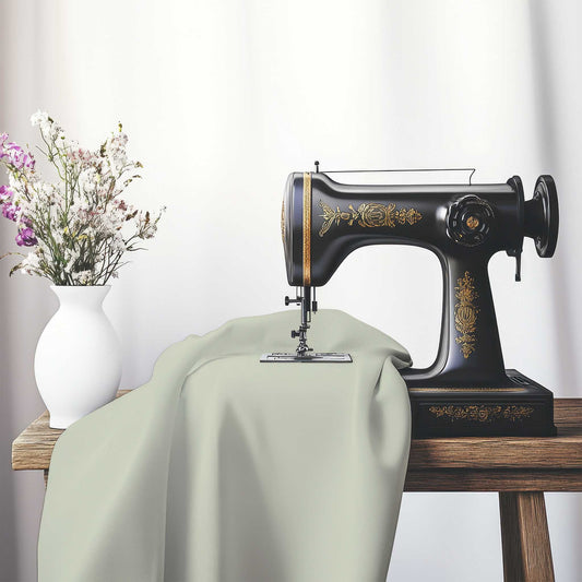 Pale Green Cotton Sateen Fabric, FACS-1241-999, on an antique sewing machine sitting on a desk with vase of beautiful flowers.