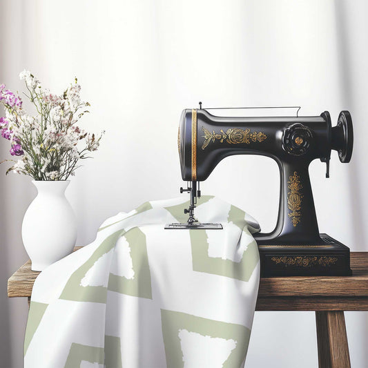 Off-White Cotton Sateen Fabric with Bold Pale Green Graphic , FASC-1241-391, on an antique sewing machine sitting on a desk with vase of beautiful flowers.