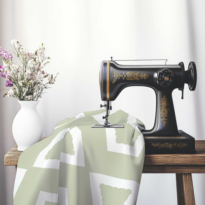 Pale Green Cotton Sateen Fabric with Bold Off-White Graphic , FASC-1241-392, on an antique sewing machine sitting on a desk with vase of beautiful flowers.