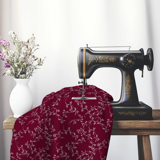 Burgundy Red Cotton Sateen Fabric with Off-White Vine Print , FASC-1281-182, on an antique sewing machine sitting on a desk with vase of beautiful flowers.