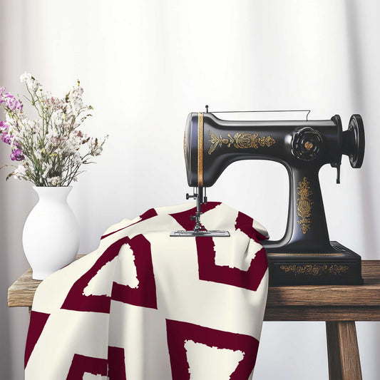 Pale Cream Cotton Sateen Fabric with Bold Burgundy Red Graphic , FASC-1283-391, on an antique sewing machine sitting on a desk with vase of beautiful flowers.