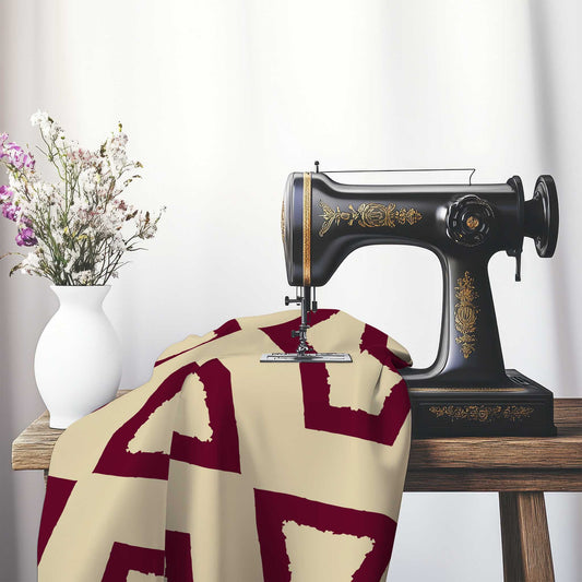 Tan Cotton Sateen Fabric with Bold Burgundy Red Graphic , FASC-1284-391, on an antique sewing machine sitting on a desk with vase of beautiful flowers.