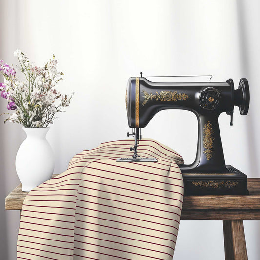 Cotton Sateen Fabric with Fine Burgundy Red Stripes on Beige, FACS-1285-151, on an antique sewing machine sitting on a desk with vase of beautiful flowers.