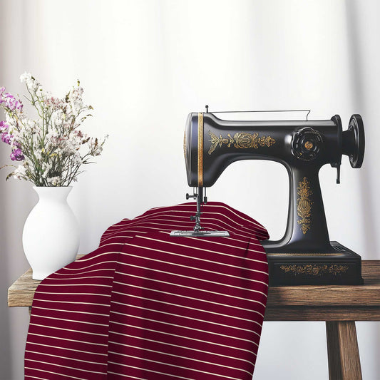 Cotton Sateen Fabric with Fine Beige Stripes on Burgundy Red, FACS-1285-152, on an antique sewing machine sitting on a desk with vase of beautiful flowers.