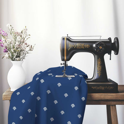 Royal Blue Cotton Sateen Fabric with Off-White Hand-painted Swizzle Motif Print, FASC-1291-172, on an antique sewing machine sitting on a desk with vase of beautiful flowers.