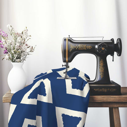 Royal Blue Cotton Sateen Fabric with Bold Pale Cream Graphic , FASC-1293-392, on an antique sewing machine sitting on a desk with vase of beautiful flowers.