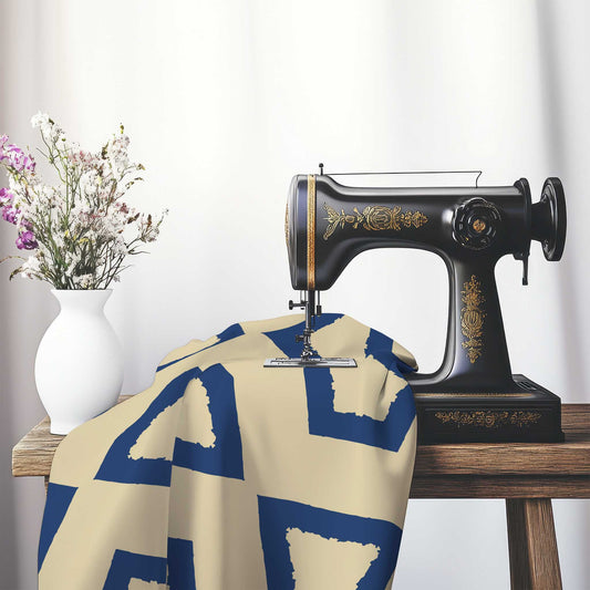 Tan Cotton Sateen Fabric with Bold Royal Blue Graphic , FASC-1294-391, on an antique sewing machine sitting on a desk with vase of beautiful flowers.