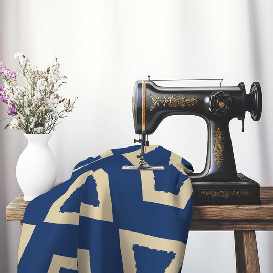Royal Blue Cotton Sateen Fabric with Bold Tan Graphic , FASC-1294-392, on an antique sewing machine sitting on a desk with vase of beautiful flowers.