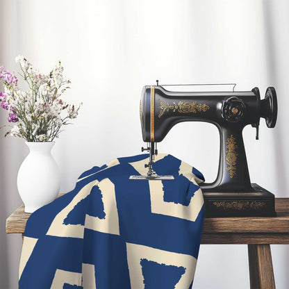 Royal Blue Cotton Sateen Fabric with Bold Beige Graphic , FASC-1295-392, on an antique sewing machine sitting on a desk with vase of beautiful flowers.
