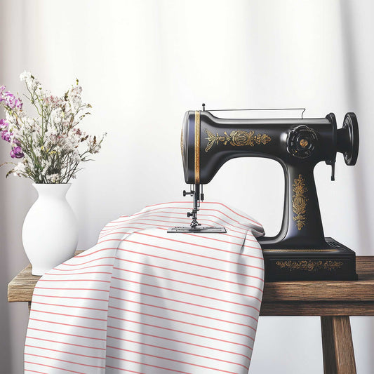 White Cotton Sateen Fabric with Fine Pink Stripes, FACS-1340-151, on an antique sewing machine sitting on a desk with vase of beautiful flowers.