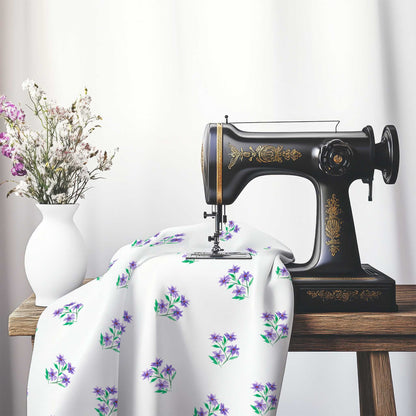 Printed Fabric with Handpainted Purple Watercolor Floral Pattern, FACS-1355, on an antique sewing machine sitting on a desk with vase of beautiful flowers.