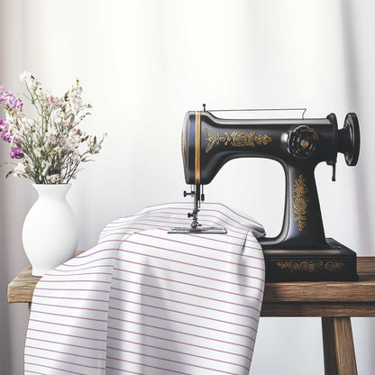 White Cotton Sateen Fabric with Fine Mauve Stripes, FACS-1360-151, on an antique sewing machine sitting on a desk with vase of beautiful flowers.