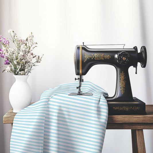White Cotton Sateen Fabric with Thin Blue Bars, FACS-1370-241, on an antique sewing machine sitting on a desk with vase of beautiful flowers.