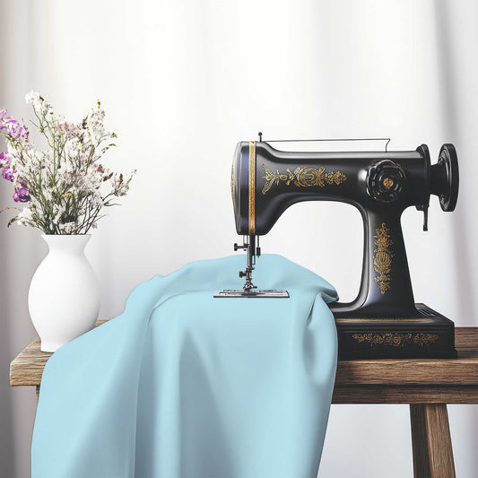 Blue Cotton Sateen Handpainted Purple Watercolor Print, FACS-1370-999, on an antique sewing machine sitting on a desk with vase of beautiful flowers.