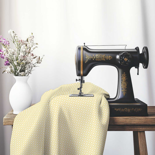 Off-White Cotton Sateen Fabric with Yellow Repeating Square Motif Print, FASC-1381-122, on an antique sewing machine sitting on a desk with vase of beautiful flowers.