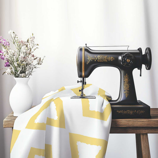 Off-White Cotton Sateen Fabric with Bold Yellow Graphic , FASC-1381-391, on an antique sewing machine sitting on a desk with vase of beautiful flowers.