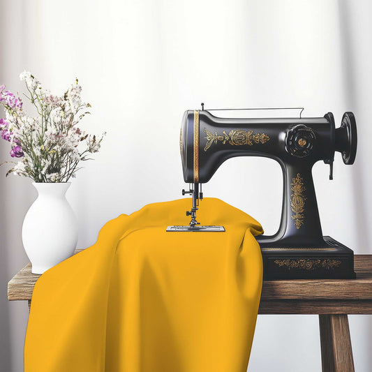 Yellow-Orange Cotton Sateen Handpainted Purple Watercolor Print, FACS-1390-999, on an antique sewing machine sitting on a desk with vase of beautiful flowers.