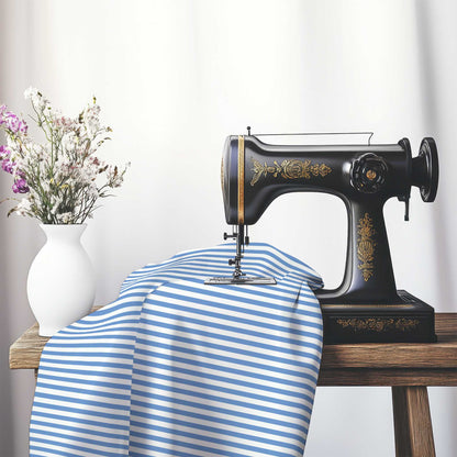 White Cotton Sateen Fabric with Thin Blue Bars, FACS-1400-241, on an antique sewing machine sitting on a desk with vase of beautiful flowers.