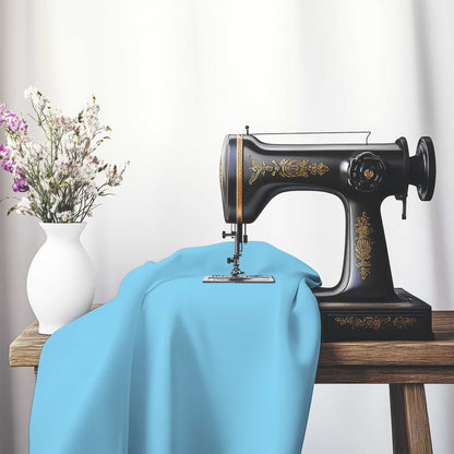 Blue Cotton Sateen Handpainted Purple Watercolor Print, FACS-1430-999, on an antique sewing machine sitting on a desk with vase of beautiful flowers.